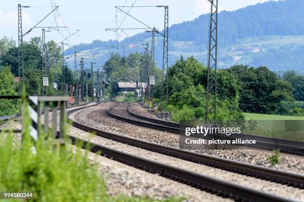 July 2018, Germany, Flintsbach Am Inn: A train of the Austrian Federal Railways driving over the tracks of the Bahntrasse through the valley of the...