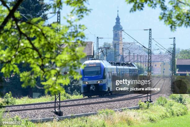 July 2018, Germany, Flintsbach Am Inn: A train of the Austrian Federal Railways driving over the tracks of the Bahntrasse through the valley of the...