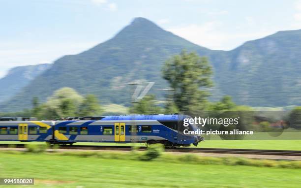 July 2018, Germany, Flintsbach Am Inn: A train of the Austrian Federal Railways driving over the tracks of the Bahntrasse through the valley of the...