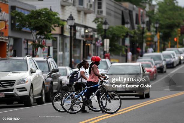 Girls cross Moody Street in Waltham, MA with their bicycles on June 7, 2018. Waltham is booming, exploding with new job growth as tech and life...