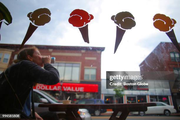 Customer sits outside of Lizzy's Homemade Ice Cream on Moody Street in Waltham, MA on June 7, 2018. Waltham is booming, exploding with new job growth...