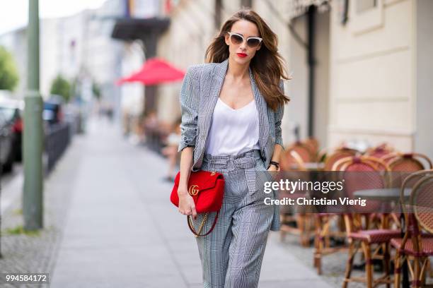 Alexandra Lapp wearing a checkered suit combination in black and white with a long blazer and high waist pants with an integrated belt both from...