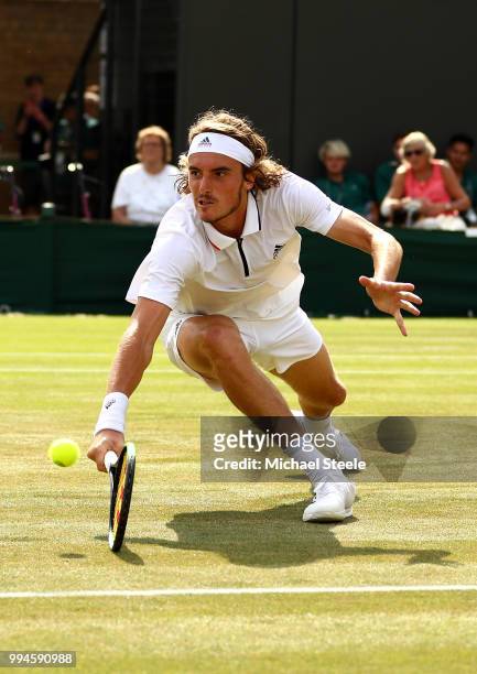 Stefanos Tsitsipas of Greece dives to play a backhand return against John Isner of the United States during their Men's Singles fourth round match on...