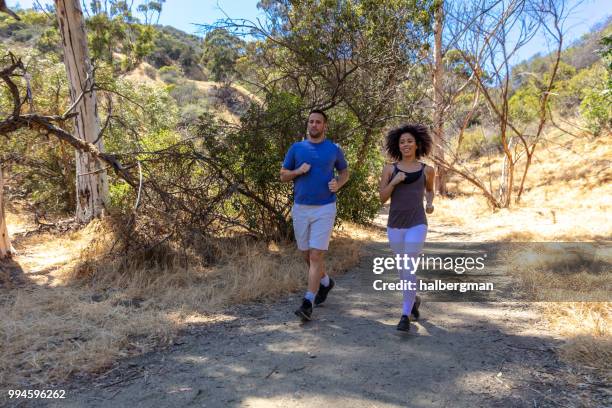 couple running in los angeles park - runyon canyon stock pictures, royalty-free photos & images