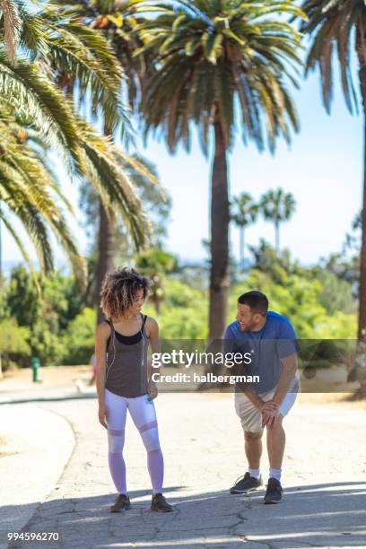 la couple stretching beneath palm trees in park - runyon canyon stock pictures, royalty-free photos & images