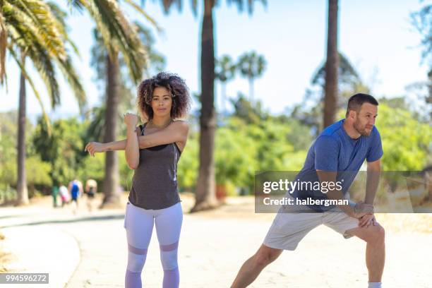 la couple stretching beneath palm trees in park - runyon canyon stock pictures, royalty-free photos & images