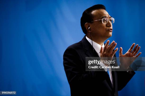 Chinese Premier Li Keqiang gestures speaks to the media together with German Chancellor Angela Merkel following Germany-China government...