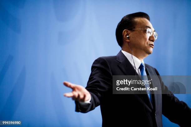 Chinese Premier Li Keqiang gestures speaks to the media together with German Chancellor Angela Merkel following Germany-China government...