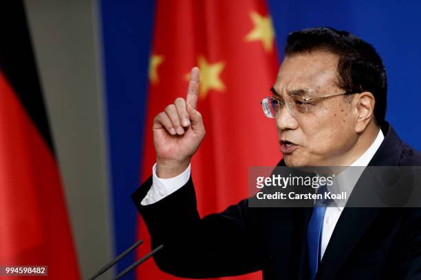 Chinese Premier Li Keqiang gestures as he speaks to the media together with German Chancellor Angela Merkel following Germany-China government...
