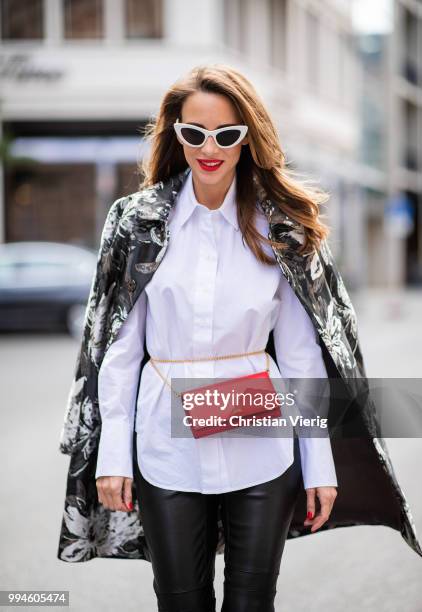 Alexandra Lapp wearing a long blazer jacket with floral prints in green, white and gold tones from Steffen Schraut, a white long shirt and slim...