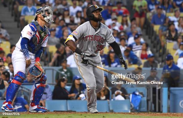 Yasmani Grandal of the Los Angeles Dodgers looks on as Gregory Polanco of the Pittsburgh Pirates hits a two run home run scoring Starling Marte of...
