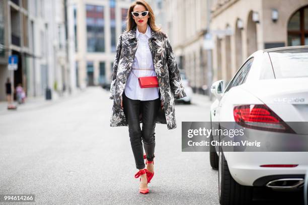 Alexandra Lapp wearing a long blazer jacket with floral prints in green, white and gold tones from Steffen Schraut, a white long shirt and slim...