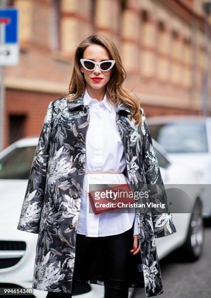 Alexandra Lapp wearing a long blazer jacket with floral prints in green, white and gold tones from Steffen Schraut, a white long shirt and slim...