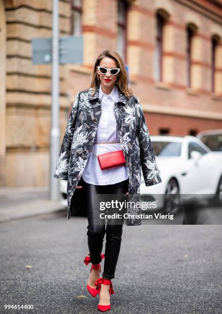 Alexandra Lapp wearing a long blazer jacket with floral prints in green, white and gold tones from Steffen Schraut, a white long shirt and slim...