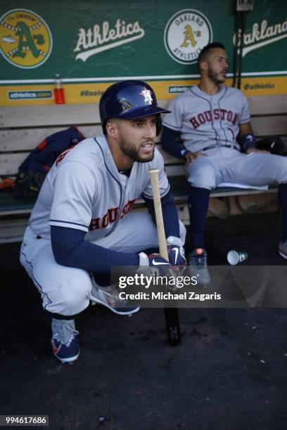 George Springer of the Houston Astros squats in the dugout prior to the game against the Oakland Athletics at the Oakland Alameda Coliseum on June...