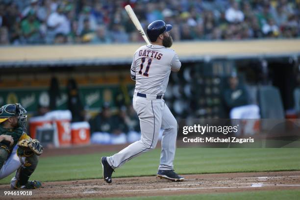 Evan Gattis of the Houston Astros hits a home run during the game against the Oakland Athletics at the Oakland Alameda Coliseum on June 12, 2018 in...