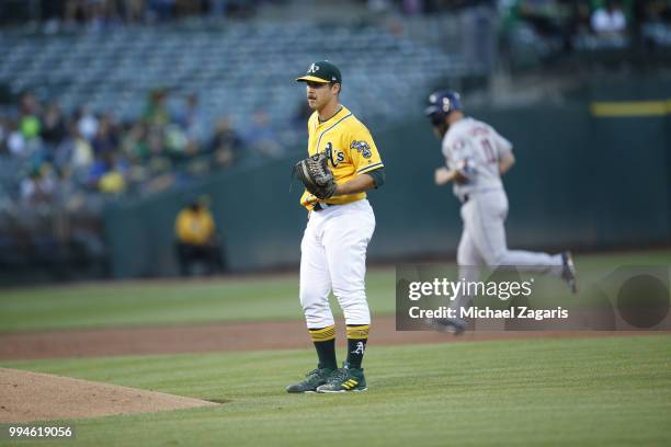 Daniel Mengden of the Oakland Athletics stands on the field while Evan Gattis of the Houston Astros runs the bases after hitting a home run during...