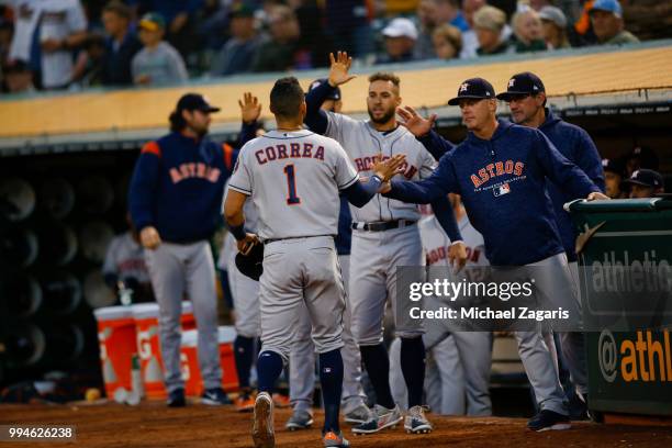 Carlos Correa of the Houston Astros is congratulated at the dugout during the game against the Oakland Athletics at the Oakland Alameda Coliseum on...