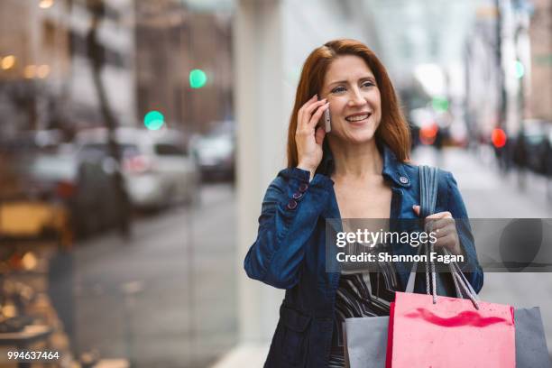 woman with shopping bags walking outdoors - downtown shopping stock pictures, royalty-free photos & images