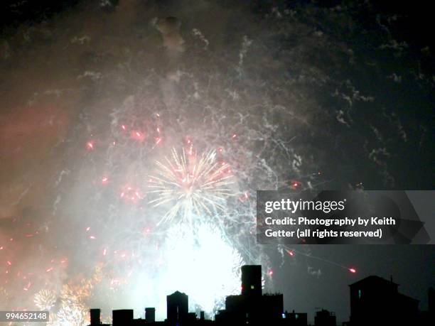 fireworks bursting above city skyline - new york spring spectacular stockfoto's en -beelden