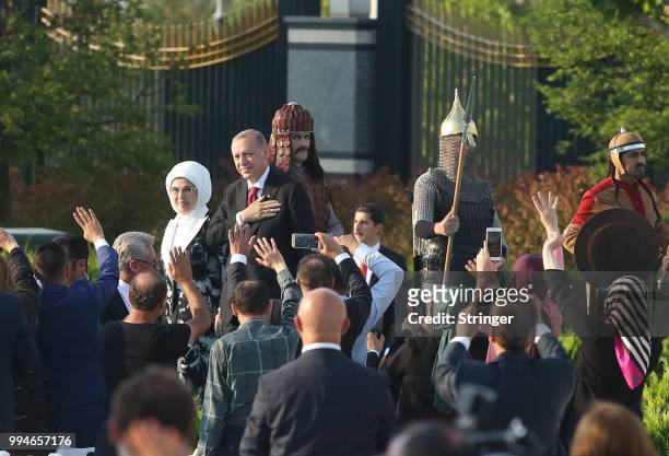 Turkey's President Tayyip Erdogan and his wife Emine Erdogan waves to supporters as they attend a ceremony at the Presidential Palace after Erdogan's...