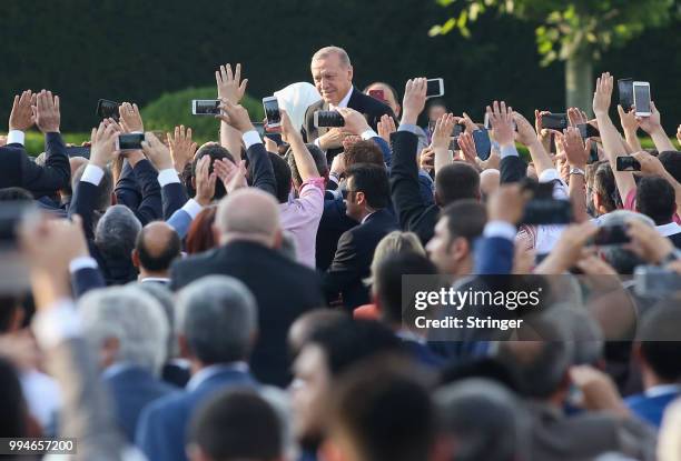 Turkey's President Tayyip Erdogan and his wife Emine Erdogan waves to supporters as they attend a ceremony at the Presidential Palace after Erdogan's...