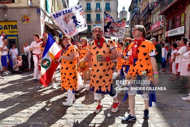 Revelers walk on the street during the San Fermin bull run festival in Pamplona, northern Spain on July 9, 2018 - Each day at 8am hundreds of people...