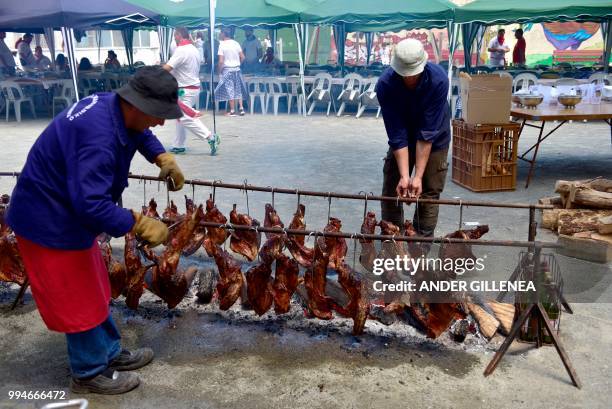 Cooks roast meat uring the San Fermin bull run festival in Pamplona, northern Spain on July 9, 2018 - Each day at 8am hundreds of people race with...