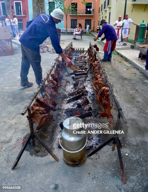 Cooks roast meat uring the San Fermin bull run festival in Pamplona, northern Spain on July 9, 2018 - Each day at 8am hundreds of people race with...