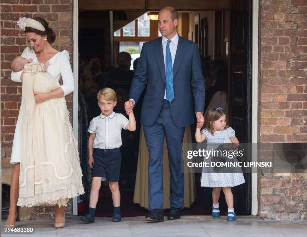Britain's Princess Charlotte of Cambridge and Britain's Prince George of Cambridge hold hands with their father, Britain's Prince William, Duke of...