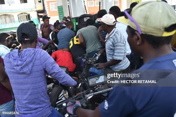 Haitian people wait to purchase fuel at a gas station in the commune of Petion Ville in the Haitian capital Port-au-Prince, July 9 one of the few gas...