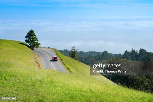 car on mountain road - wonderlust stock-fotos und bilder