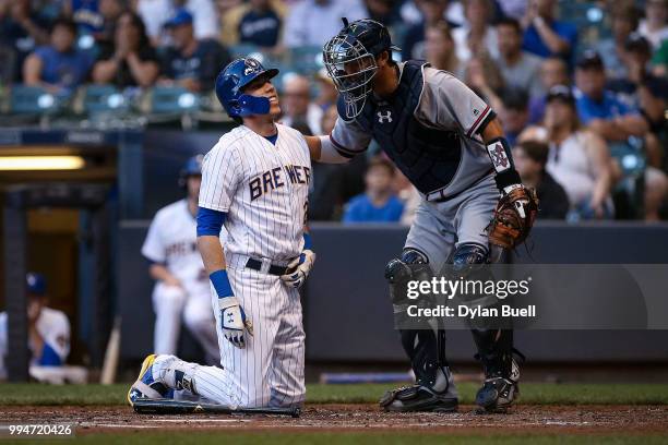 Kurt Suzuki of the Atlanta Braves checks on Christian Yelich of the Milwaukee Brewers after Yelich was hit by a pitch in the third inning at Miller...