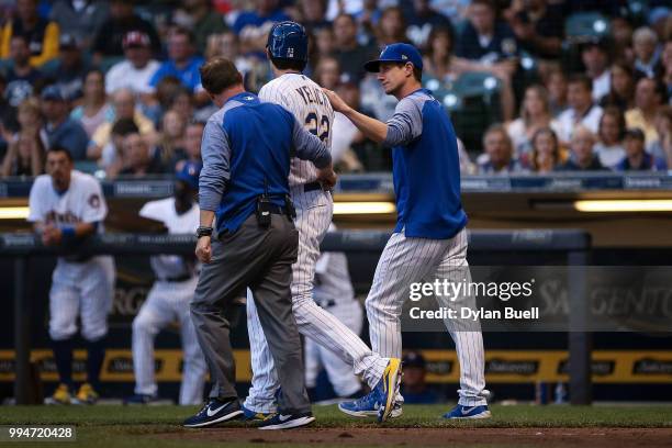 Manager Craig Counsell of the Milwaukee Brewers meet with Christian Yelich and Yelich was hit by a pitch in the third inning against the Atlanta...