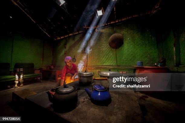 unidentified local lady preparing a lunch for family with traditional wood kitchen in cemoro lawang village of bromo, east java, indonesia. - bromo tengger semeru national park stockfoto's en -beelden