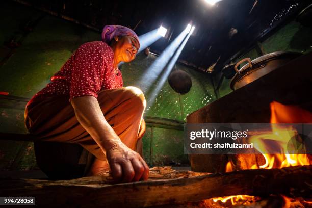 unidentified local lady preparing a lunch for family with traditional wood kitchen in cemoro lawang village of bromo, east java, indonesia. - tengger stock pictures, royalty-free photos & images