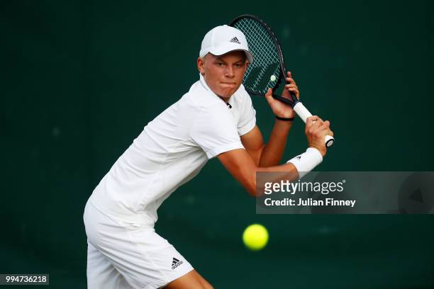 Blu Baker of Great Britain plays a backhand in his Boys' Singles first round match on day seven of the Wimbledon Lawn Tennis Championships at All...