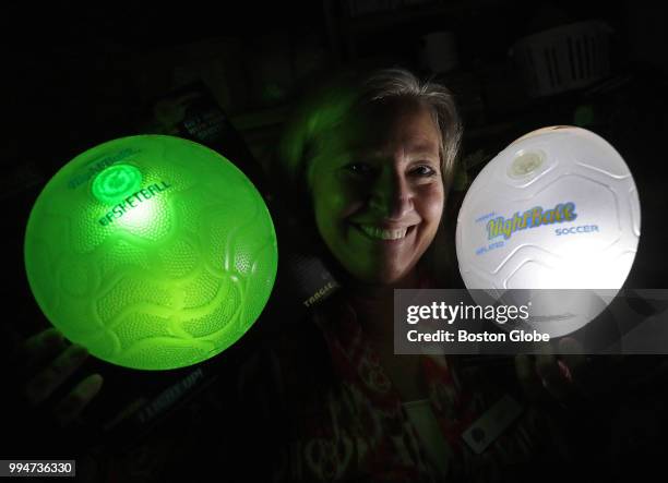 Kathy Detwiler, owner of Buttonwood Books and Toys in Cohasset, MA. Poses with glow in the dark sport balls, one of the popular new toys for this...