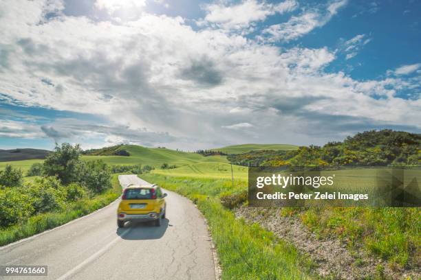 highway in tuscany with a motion blurred car - car country road photos et images de collection