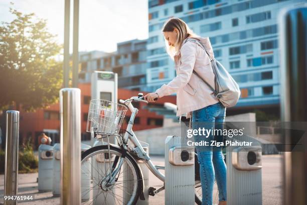 girl getting ready to grab a bike and go to the city - three wheeled vehicle stock pictures, royalty-free photos & images