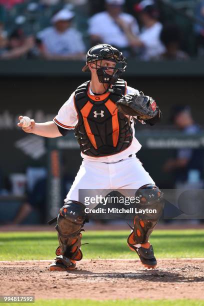Chance Sisco of the Baltimore Orioles looks to throw to second base during a baseball game against the Seattle Mariners at Oriole Park at Camden...