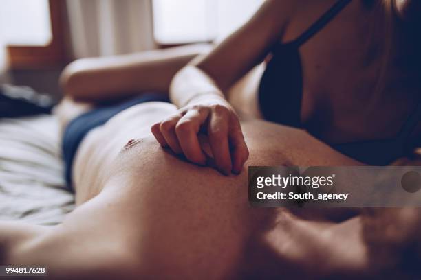 couple cuddling in the bed - alluring stock pictures, royalty-free photos & images