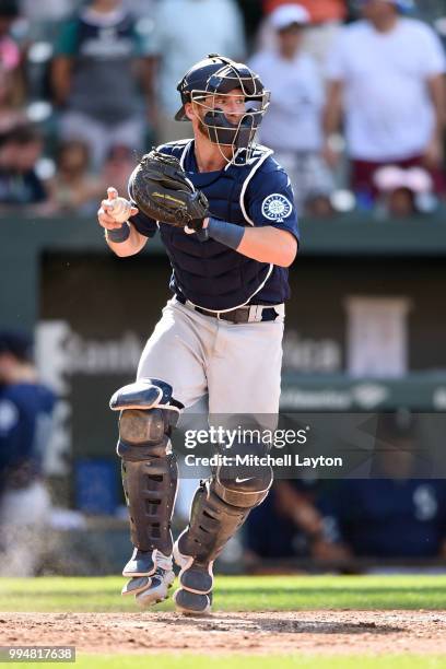 Chris Herrmann of the Seattle Mariners looks to throw to second base during a baseball game against the Baltimore Orioles at Oriole Park at Camden...