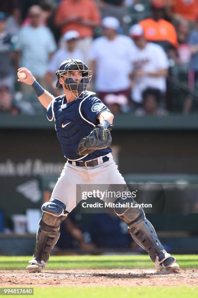 Chris Herrmann of the Seattle Mariners looks to throw to second base during a baseball game against the Baltimore Orioles at Oriole Park at Camden...