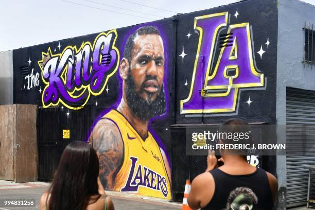 People photograph a mural of LeBron James in a Los Angeles Lakers jersey in Venice, California on July 9, 2018. - It was originally revealed July 6...