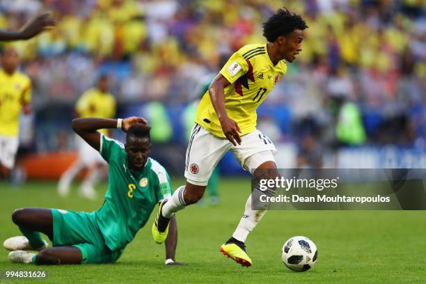 Juan Cuadrado of Colombia is challenged by Salif Sane of Senegal during the 2018 FIFA World Cup Russia group H match between Senegal and Colombia at...