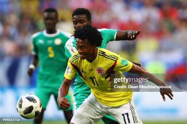 Juan Cuadrado of Colombia is challenged by Moussa Wague of Senegal during the 2018 FIFA World Cup Russia group H match between Senegal and Colombia...