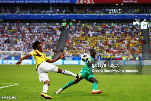 Youssouf Sabaly of Senegal tackles Juan Cuadrado of Colombia during the 2018 FIFA World Cup Russia group H match between Senegal and Colombia at...