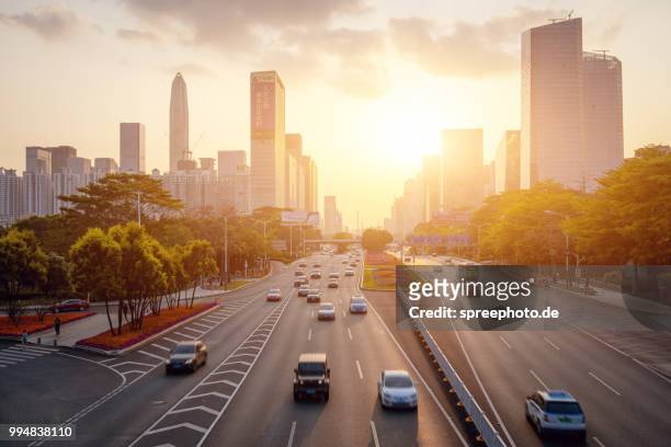 china, shenzhen skyline panorama with traffic - street sunset stock-fotos und bilder