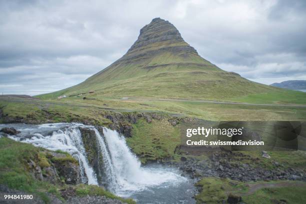 avec cascade kirkjufellsfoss en islande contre ciel couvert, aucun peuple spectaculaire montagne kirkjufell - islande du centre ouest photos et images de collection